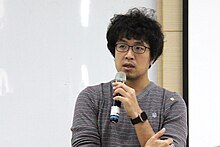 Puma Shen is giving a speech with a microphone.