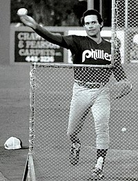 A man in light baseball pants and a dark jersey