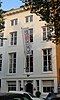 Koopmanshuis, met gebosseerde, natuurstenen lijstgevel. In de door een cordonlijst van de bel-etage gescheiden onderpui een rijk gesneden voordeur, Lodewijk XIV. Rijke interieurs in Lodewijk XIV, XV- en XVI-stijl