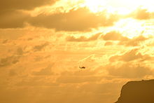 SH-60B Seahawk helicopter from HSL-49 returning to NAS North Island, San Diego, CA in 2014. Point Loma can be seen clearly in the background. SH-60B Seahawk helicopter sunset Point Loma San Diego 2014.JPG