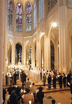 Liturgia a Közösség első alapításának templomában, a párizsi Saint-Gervais templomban. Megfigyelhető bal oldalon a férfi, jobboldalt a női szerzetesek oszlopa; ez utóbbiak fátyolban