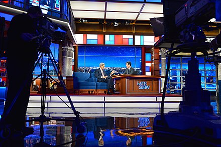 The Late Show with Stephen Colbert stage, with Stephen Colbert interviewing then-U.S. Secretary of State John Kerry in 2015