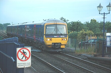 A First Great Western Class 165 train from Oxford to Banbury passing through the crossing into Tackley station