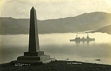 The HMS New Zealand in Akaroa Harbour with the Britomart Monument in the foreground The HMS 'NZ' in Akaroa Harbour with the Britomart Monument in the foreground (14576932958).jpg