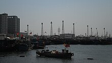 A set of seven skeletal steel towers on the shore