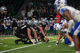 The North Dakota football team lines up on offense before the snap during a game against Indiana State in 2023 UND Hawks and ISU Sycamores honor Military Appreciation Day (8098000).jpg