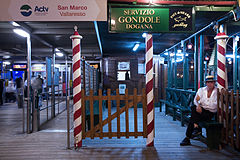 Vallaresso Vaporetto stop with Gondola service and a gondolier in Night Watch. Venice, Italy 2009