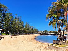 Views over West Manly Cove Beach, the ocean pool and Manly Wharf.