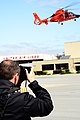 A NATO officer takes a photo of a helicopter demonstration at Coast Guard Air Station San Francisco 140603-G-XX113-227.jpg