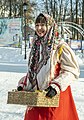 A girl with a box of sweets for children at the Maslenitsa festival