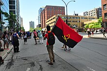 Man with Angolan flag, Montreal, Carifiesta 2018 Angola Flag - Montreal (29524539128).jpg