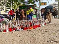 People lighting candles at the accident scene