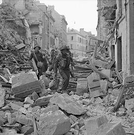 Британські солдати просуваються крізь руїни міста Кан. Операція «Чарнвуд». 9 липня 1944