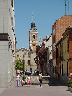 Calle con campanario de iglesia al fondo en Getafe.jpg