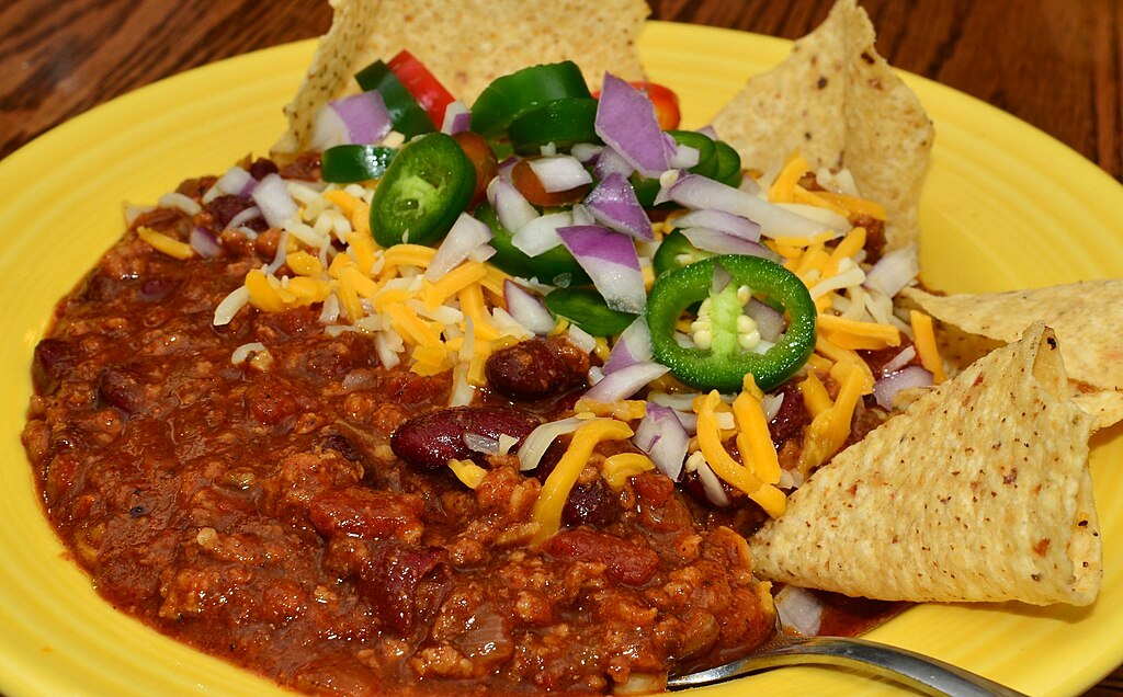 Chili with garnishes and tortilla chips