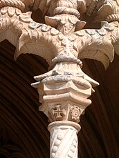 Capitel, en el claustro de Juan I, en el Monasterio de la Batalha, donde es visible uno de los dos motivos emblemáticos del estilo manuelino, la Cruz de Cristo.