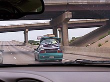 A hatchback carrying an excessive amount of cargo, secured to the vehicle using duct tape Duct-tape Moving Van from behind.jpg