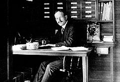 Photograph of George Ellery Hale at work at his desk.