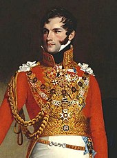 Portrait, huile sur toile, d'un prince en buste portant un uniforme militaire : veste rouge, gilet doré orné de décorations et pantalon blanc. Le visage grave, cheveux noirs, il regarde vers sa droite.