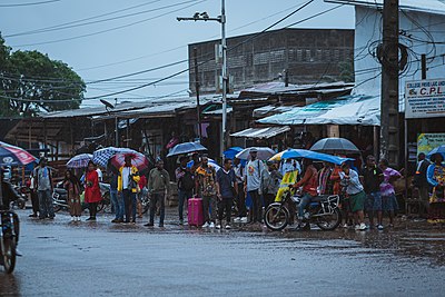 Des personnes attendant, sous parapluie, Certains le taxi / moto, d'autres la baisse ou l'arret de pluie