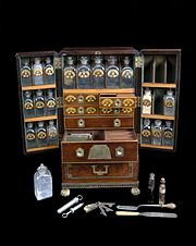 https://upload.wikimedia.org/wikipedia/commons/thumb/f/f4/Medicine_chest%2C_winged_front%2C_from_Reece%27s_Medical_Hall%2C_Pic_Wellcome_L0058280.jpg/180px-Medicine_chest%2C_winged_front%2C_from_Reece%27s_Medical_Hall%2C_Pic_Wellcome_L0058280.jpg