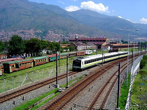 Medellin Metro alongside old trains belonging to the Antioquia Railway Metro de Medellin-Antiguos trenes.jpg