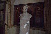 The bust of Gladstone by the club's front entrance. The inscription alludes to Gladstone's 1872 speech in which he argued 'The principle of Liberalism is trust in the people, qualified by prudence. The principle of Conservatism is mistrust of the people qualified by fear.'. National Liberal Club Gladstone bust entrance.jpg