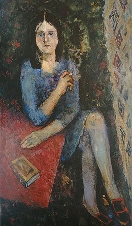 Portrait en pied d'une femme à la peau claire, aux yeux bleus et aux longs cheveux bruns, vêtue d'une robe bleu clair, attablée en plein air et fumant une cigarette.