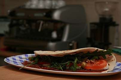 Piadina farcida amb bresaola, mozzarella, tomàquet, ruca i olives