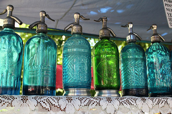 Five blue soda siphons, and one green one.