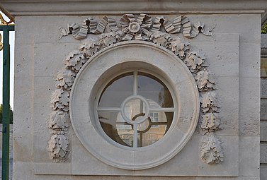 Louis XVI round window of the Petit Trianon (Versailles, France), with a festoon-derived ornament at the top
