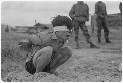 Captured Viet Cong soldier, blindfolded and tied in a stress position by American forces during the Vietnam War, 1967 Thuong Duc, Vietnam....A Viet Cong prisoner awaits interrogation at the A-109 Special Forces Detachment in Thuong... - NARA - 531447.tif