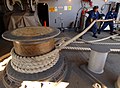 Navy sailors tailing motor driven capstan still used on US Nimitz 2005. Once again capstan for power pull, and contrasting bollard post for anti-pull of brakeforce.