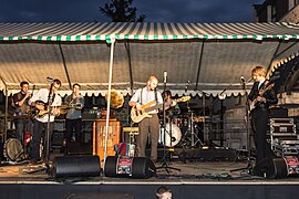 Um grupo musical em um palco ao ar livre.