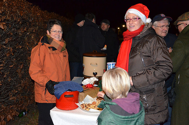 File:2013-12-21 9. Nachbarschaftstreffen Schwalbenberg, Celle, Angelika Meyer bietet selbstgebackene Kekse und heisse, nicht-alkoholische Getränke an, über die sich nicht nur Babette Märker unter ihrer Weihnachtsmütze freut.jpg