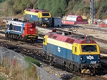 Foto colorida tirada de cima mostrando três locomotivas em ramais.