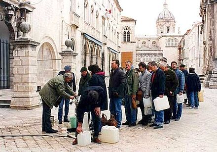 People queue at a water pipe during the siege