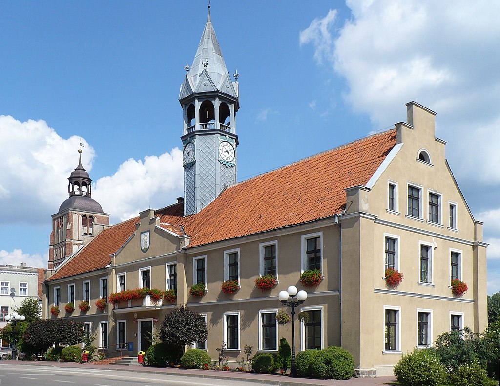 XIX-wieczny neogotycki ratusz w Barczewie. W tle widać wieżę kościoła św. Anny z przełomu XVIII i XIX wieku