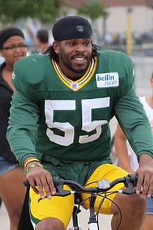 Bishop riding a bike in his Packers uniform