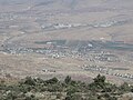 The few closest houses on the right are Ein al-Beida. The majority of closer houses are Ras al-Far'a. The green area is the valley of Tirtza. Behind it is green houses of Tammun. Further behind is part or Tubas.