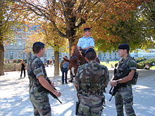 French soldiers stand guard in the Carrousel Garden in Paris during a Vigipirate patrol. French soldiers & mounted police near Place du Carrousel 2.JPG