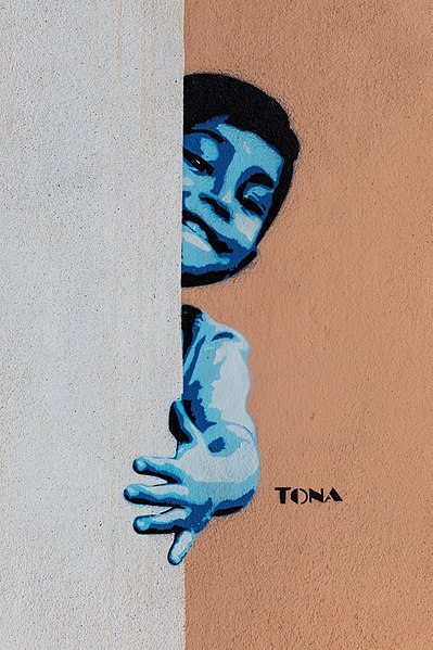 File:Graffiti of a boy popping out from behind a wall, by German artist Tona, in Vang Vieng, Laos.jpg