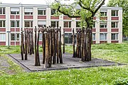 Die Skulptur Gruppenfigur 70fach von Schang Hutter steht in Freiburg im Breisgau in der Sautierstraße vor der Kantine der Oberfinanzdirektion