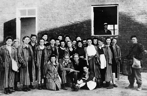 Another photo of camp inmates with the liberators, notably showing female prisoners, who were moved to the camp in the final days of its existence