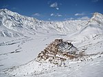 A monastery in a mountain valley covered by snow
