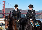 Två ridande poliser tillhörande U.S. Park Police i San Francisco med Golden Gate-bron i bakgrunden.