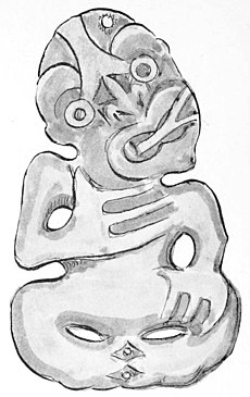 A standard B type tiki showing the double tongue which in this case is pointed to the side of the mouth. Right hand over the heart and the left hand resting on the left thigh.