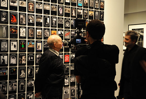 Delpire standing beside a display of Photo Poche books at the retrospective exhibition Delpire & Co. at Maison Européenne de la Photographie, Paris, 2