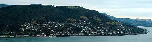 Ravensbourne and Maia appear in this view from Shiel Hill on the southern side of Otago Harbour. One of the railway causeways at Burkes is visible at the far right. The television transmitter on the top of Mount Cargill is visible behind Signal Hill in the background.