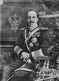 A portrait of a sitting man (Adolfo IV) facing the camera and wearing early 20th century military uniform.